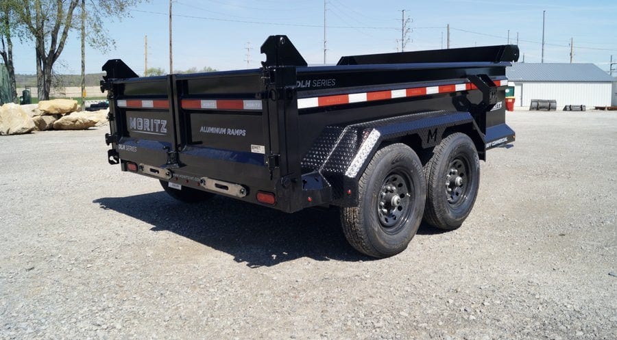 The rental dump trailer from the rear quarter, showing the barn-door tailgate and folding ramps.