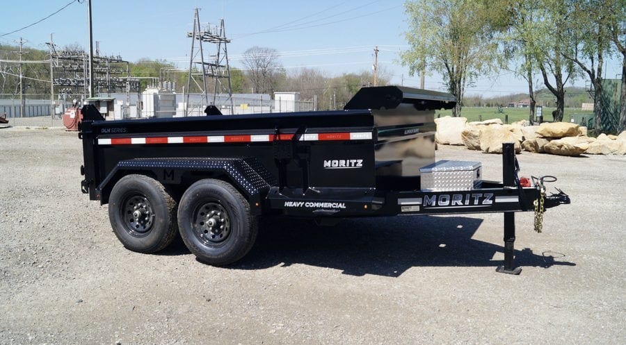 The dump trailer available for rental, shown from the side with its tandem axles and rear ramps.