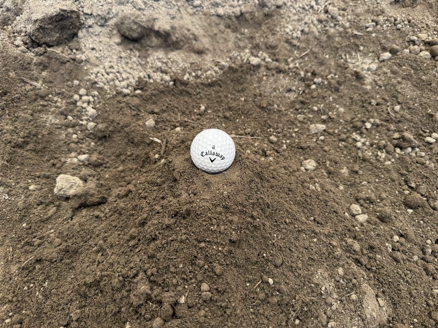 A pile of screened brown soil, shown with a golf ball for scale.
